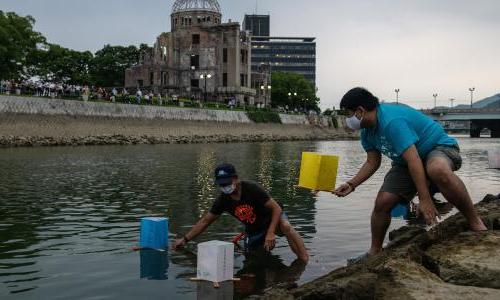 日本广岛，人们在天马河上漂浮纸灯笼.